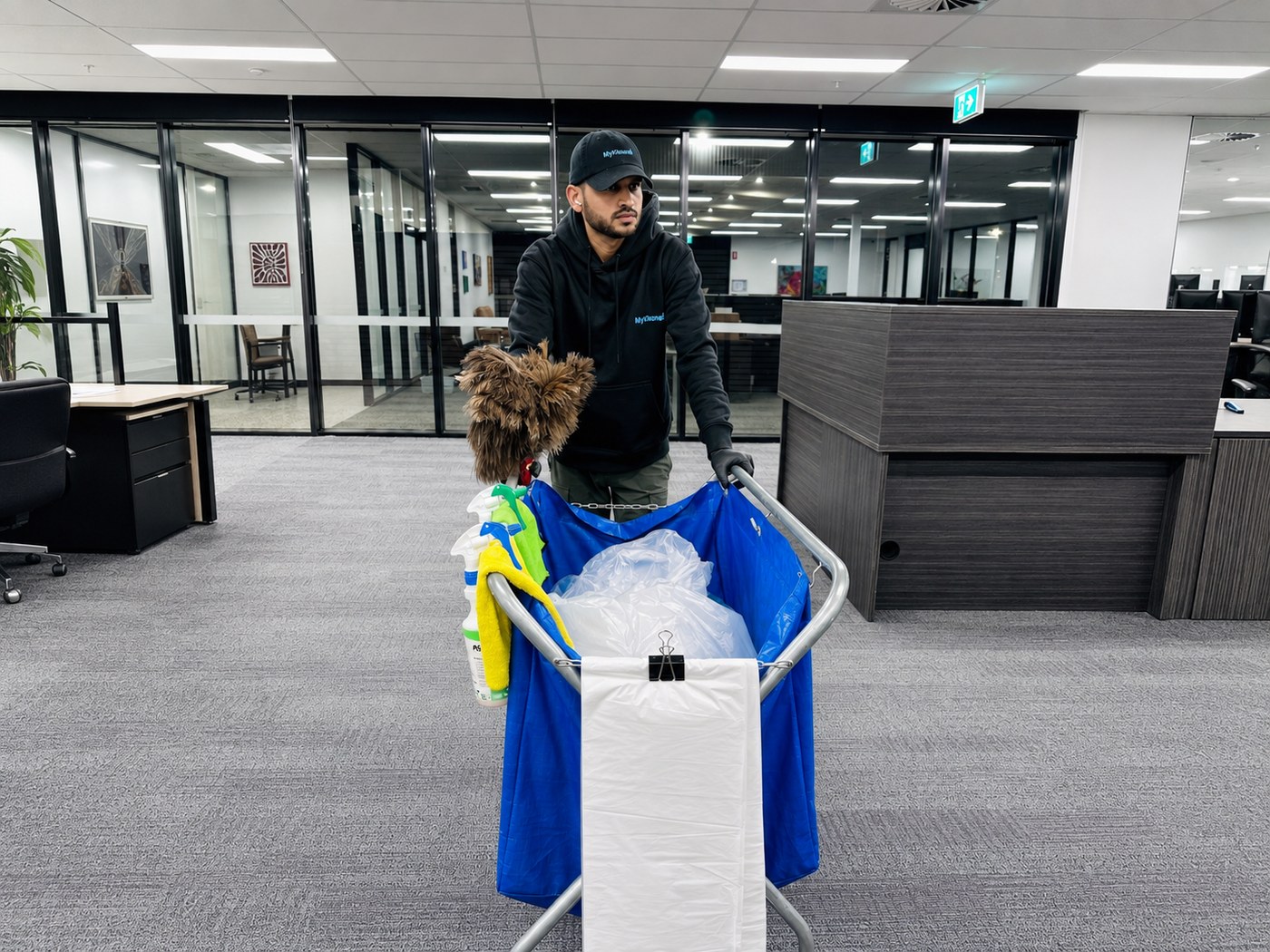 MyKleaner technician performing office cleaning with a fully equipped cleaning cart